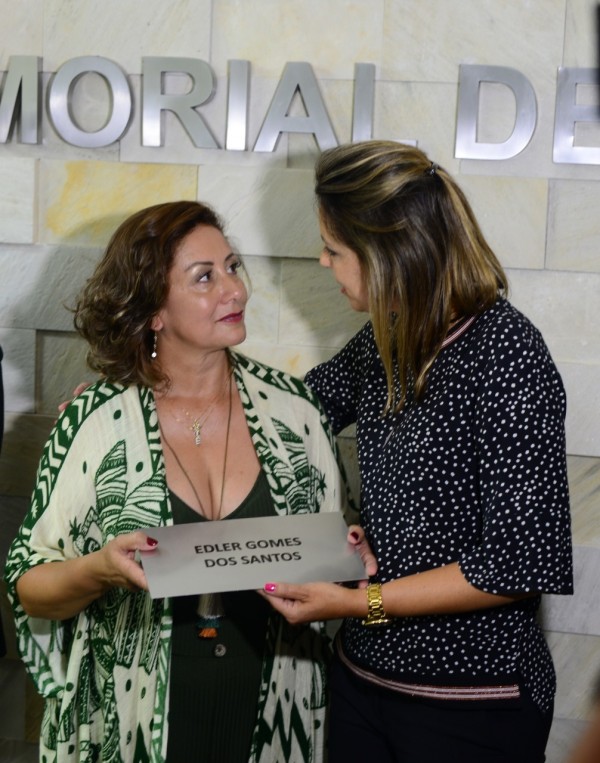A viúva de Edler recebe, das mãos da Chefe de Polícia, delegada Nadine Anflor, placa com o nome do ex-policial