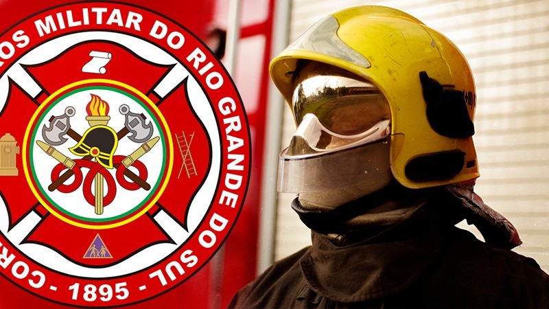À direita da imagem, o brasão do CBMRS aplicado sobre a foto. À esquerda, um bombeiro em meio corpo, vestindo roupa preta de proteção contra fogo e um capacete amarelo com viseira transparente.