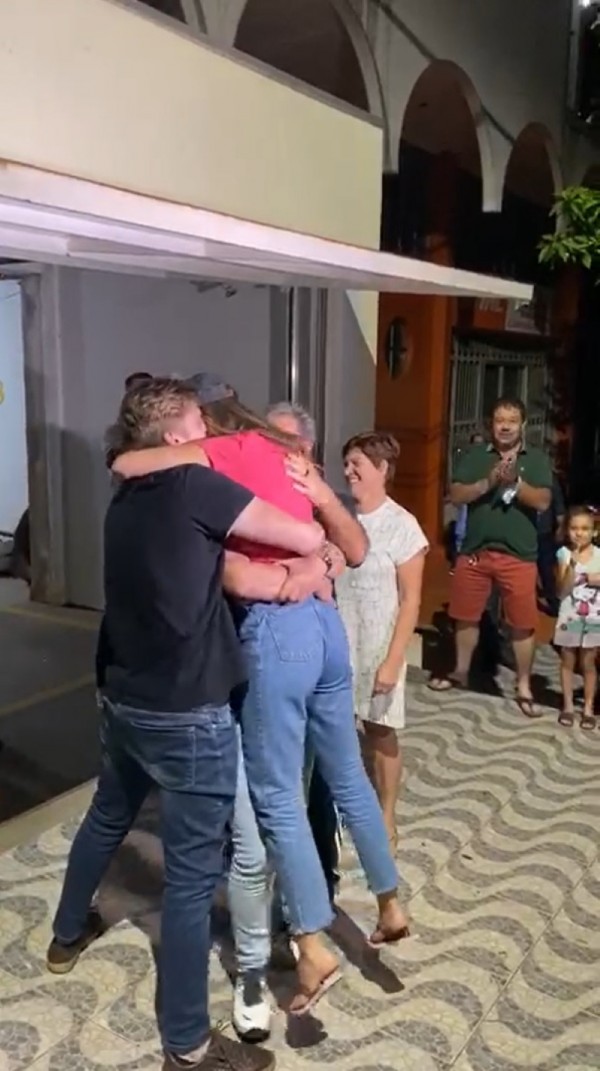 Dois homens abraçam e levantam do chão uma mulher, vítima de sequestro que foi libertada pela Polícia Civil do RS, em frente à casa da família, na cidade de Laranjeiras do Sul (PR).