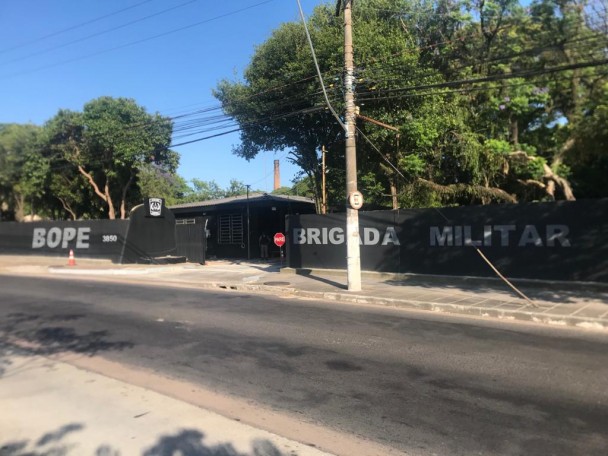 Fachada da nova sede do Bope. Muro preto com a inscrição BOPE, um portão, e outro muro com a inscrição Brigada Militar.