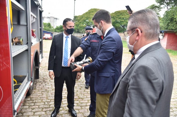 Governador, vice-governador e secretário adjunto da Segurança observam equipamentos de um dos novos caminhões dos bombeiros.