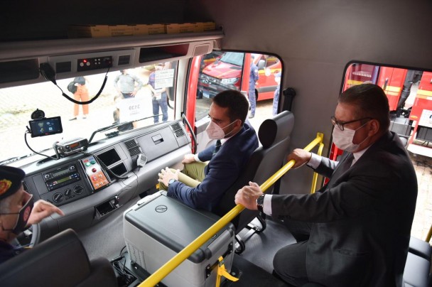 Comandante-geral do CBMRS, coronel César Bonfanti, à direita, no banco do motorista de um caminhão de bombeiros, detalhou funcionalidades das novas viaturas ao governador, no banco do carona, e ao vice, no banco da traseira para passageiros.