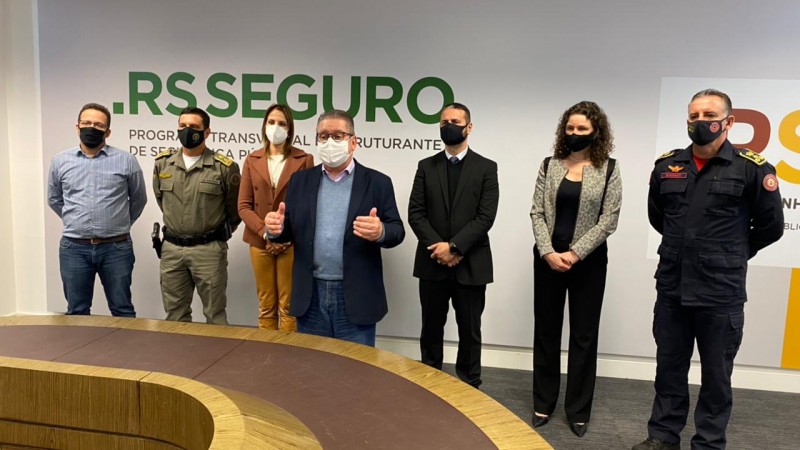 Diante de um painel com a marca do RS Seguro, da esquerda para direita, Marcelo Soletti, coronel Vanius Santarosa, delegada Nadine Anflor, delegado Ranolfo Vieira Júnior, coronel Marcelo Frota, perita criminal Heloísa Kuser, coronel César Bonfanti.