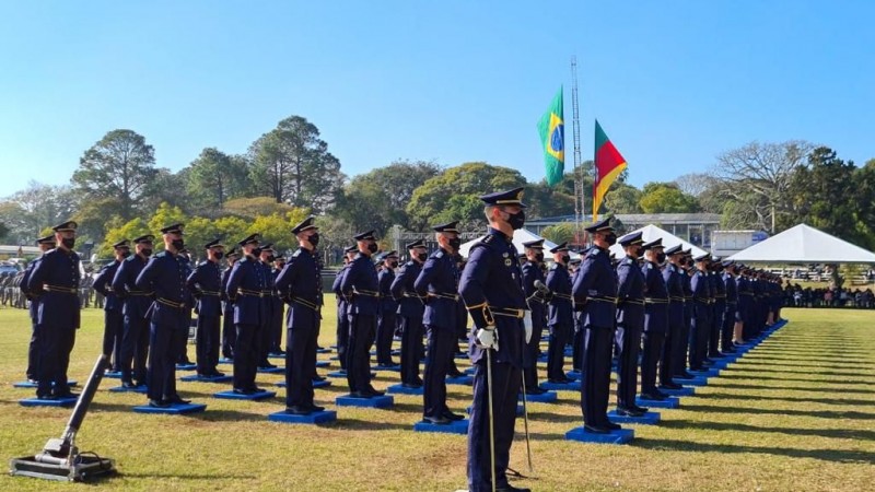 alunos-oficiais fardados, em forma lado a lado em um campo aberto