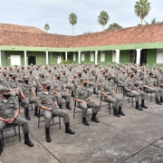 alunos-oficiais sentados em ambiente aberto durante instrução