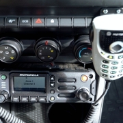 imagem em detalhe de um radio comunicador, instalado em um veículo da Polícia Militar, no painel da viatura