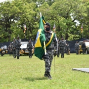Policial Militar conduzindo a bandeira nacional para o centro do evento
