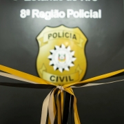 Fita de inauguração com o logo da PC atrás.