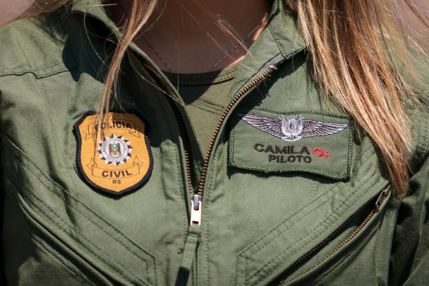 Detalhe do uniforme de voo, com o nome da escrivã Camila e o brasão da Polícia Civil