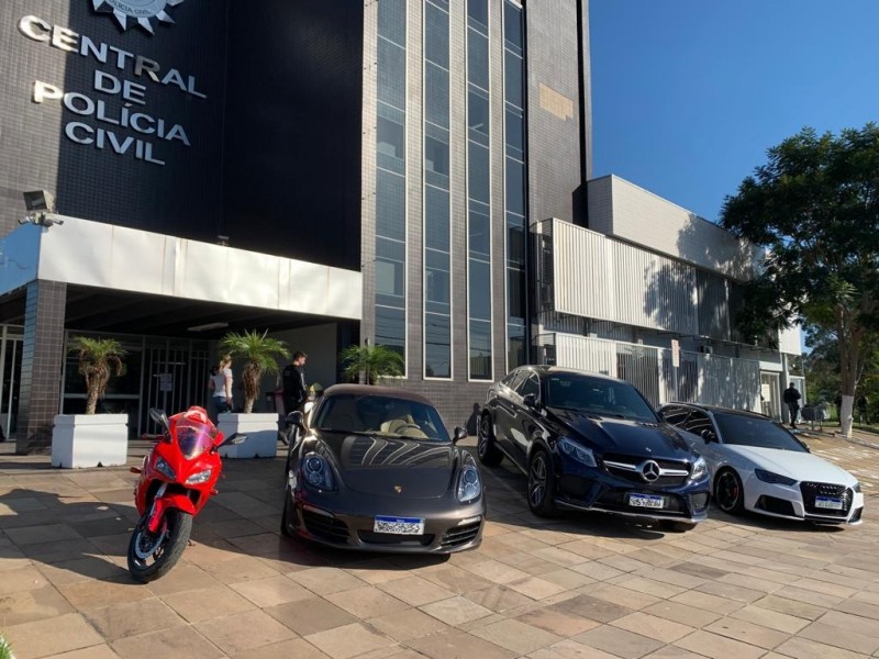 Veículos que foram apreendidos em operação da Polícia Civil, estacionados em frente de uma Delegacia de Polícia