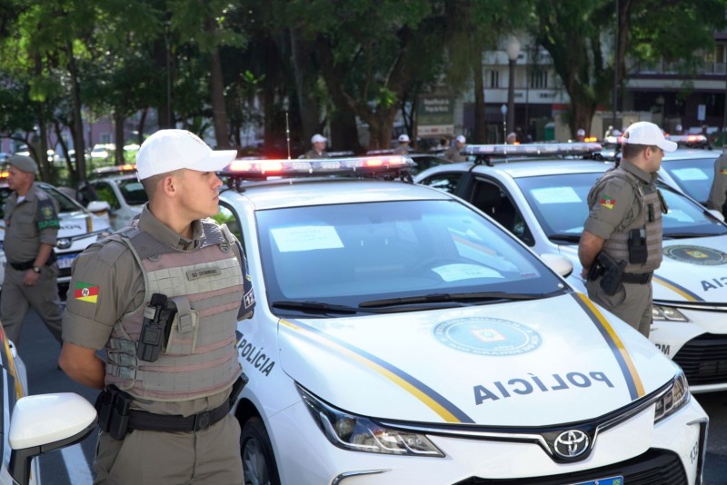 Policiais militares parado ao lado de viaturas semiblindadas