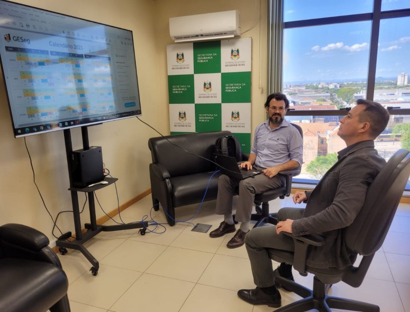 A foto mostra o secretário conversando com Sandro Caron