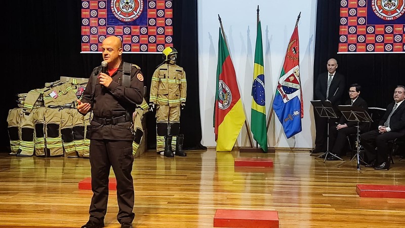 Foto mostra Comandante-Geral do CBMRS, coronel Eduardo Estêvam, de pé, com microfone, em palco durante solenidade.