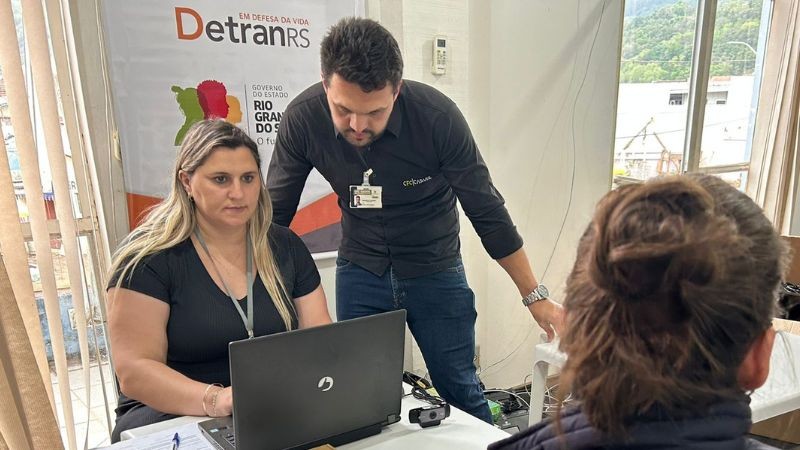 A foto mostra uma servidora realizando atendimento