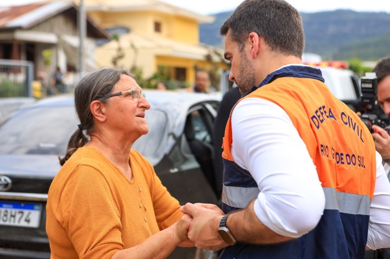 A foto mostra o governador conversando com uma senhora