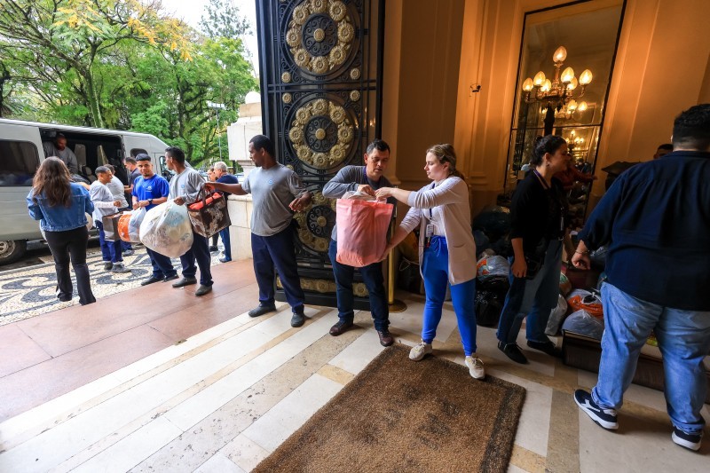 A foto mostra pessoas no Palácio Piratini recebendo doações