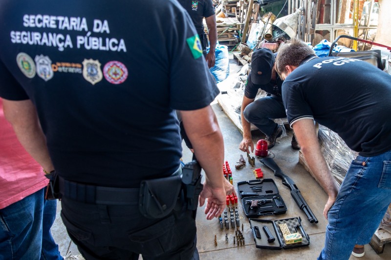 A foto mostra a apreensão de armas e munições