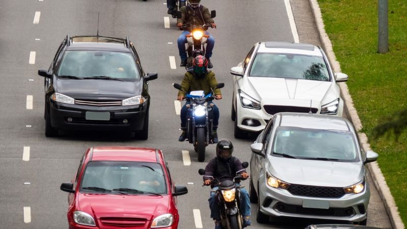 A foto mostra carros e motos