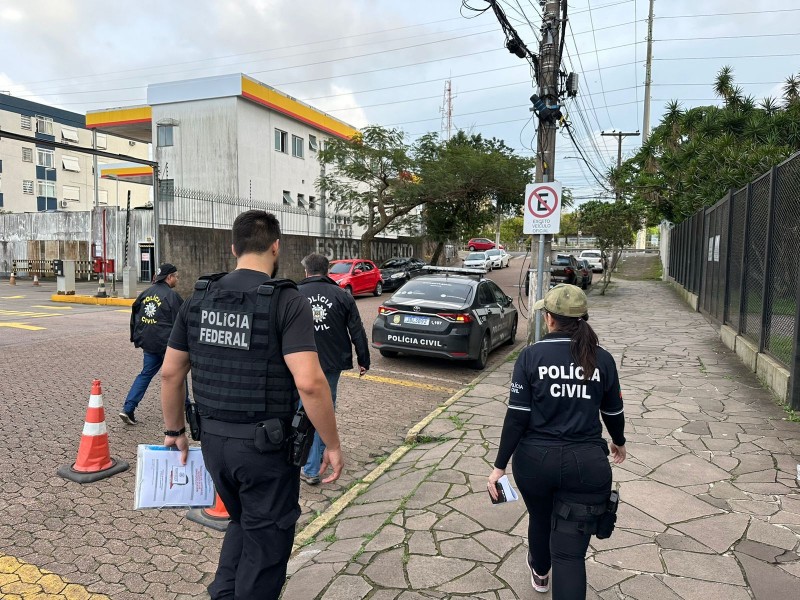A foto mostra policiais caminhando na rua