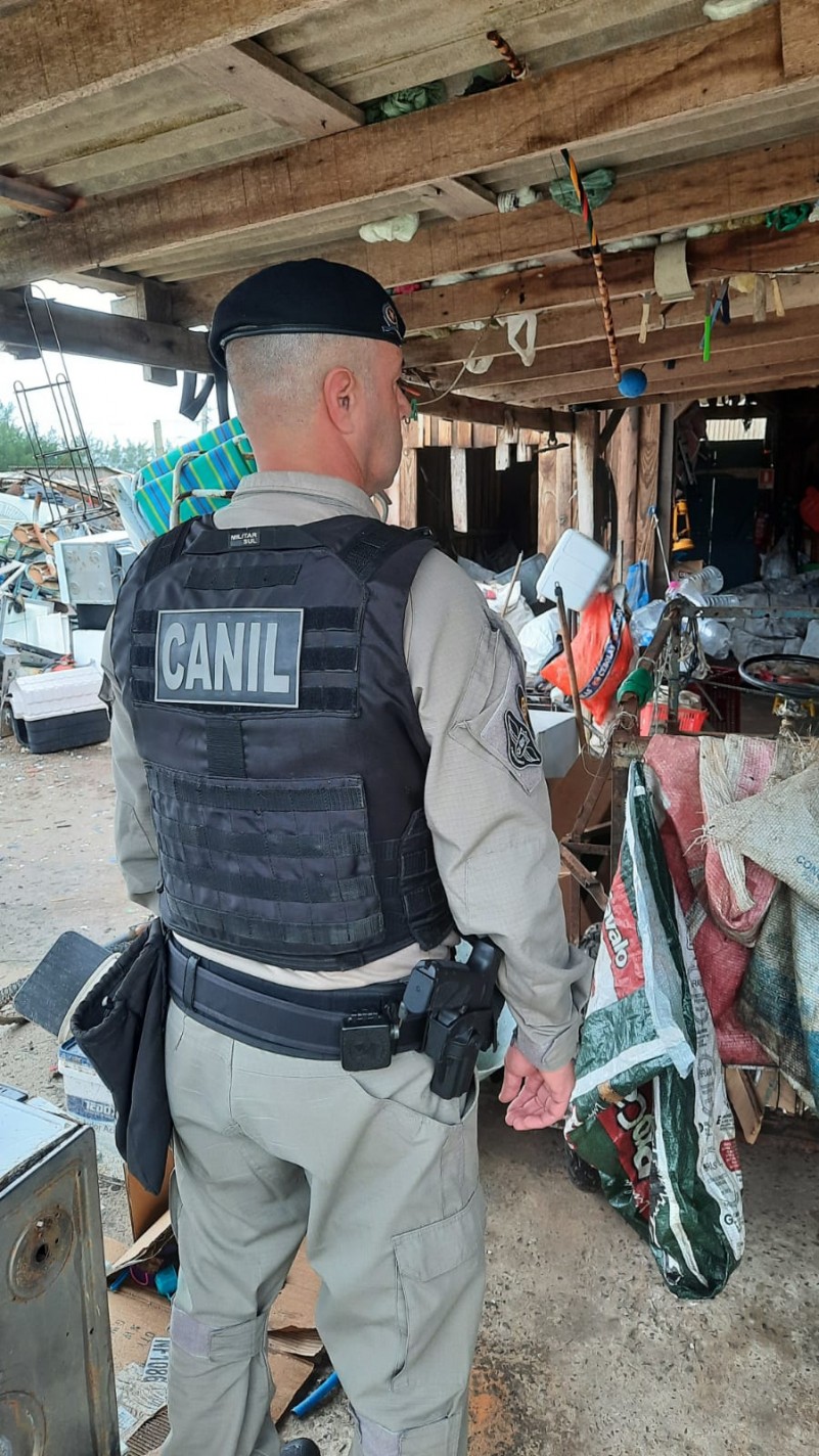 A foto mostra um policial militar vistoriando um estabelecimento