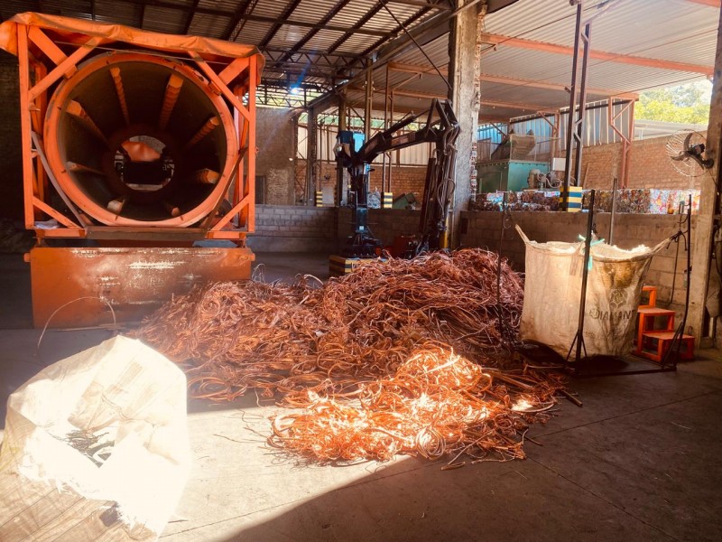 A foto mostra fio de cobre no chão em um depósito
