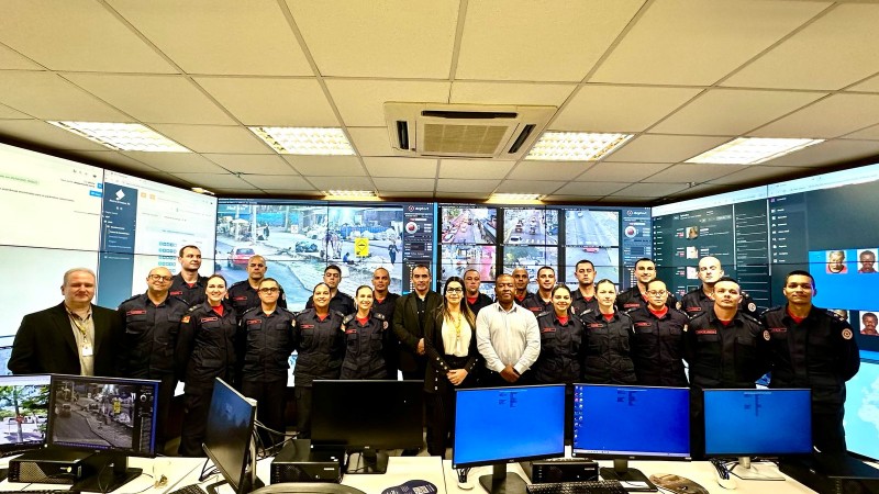 Alunos e instrutores possam para foto em uma sala de monitoramento da SSP
