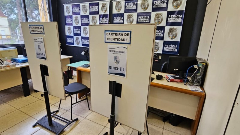 Foto do novo posto, com logotipos do IGP ao fundo. Na foto há duas mesas de atendimento com cadeiras e, atrás destas, divisórias nas quais leem-se "Carteira de Identidade" e o número do guichê.