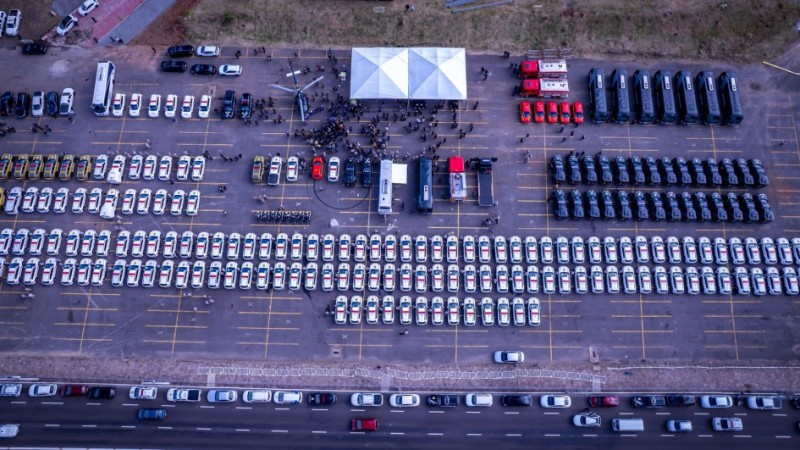 Foto aérea mostra as novas viaturas enfileiradas e agrupadas por Corporação no local do evento (o estacionamento da EPTC ao lado do estádio Beira-Rio)