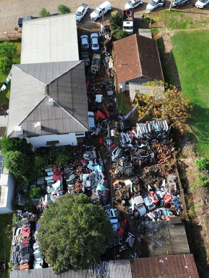 Fotografia aérea realizada por drone do desmanche fiscalizado em Ibiraiaras mostra a estrutura do estabelecimento, carcaças e peças de veículos, casas e carros