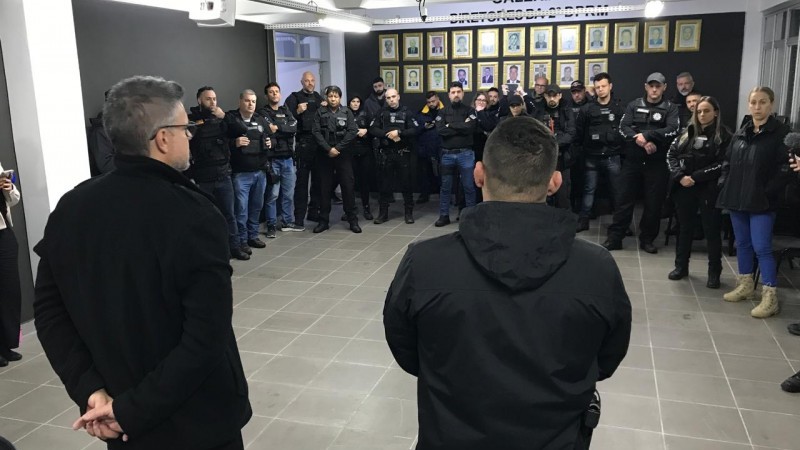 Aproximadamente 30, dos 60 agentes da Polícia Civil que participaram da operação, realizam reunião preparatória, em círculo.