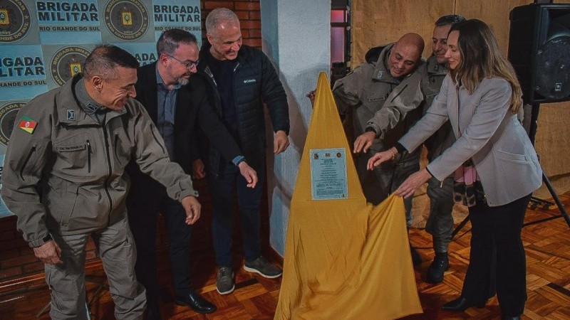 A imagens mostra representantes do comando-geral da Brigada Militar e demais autoridades na cerimônia de inauguração nova base da Corregedoria-Geral. Eles simbolicamente retiram um pano dourado e exibem uma placa que marca a inauguração.