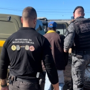 A imagem mostra um homem, que foi preso em flagrante no local, sendo conduzido por dois agentes das Forças de Segurança para uma viatura da Brigada Militar