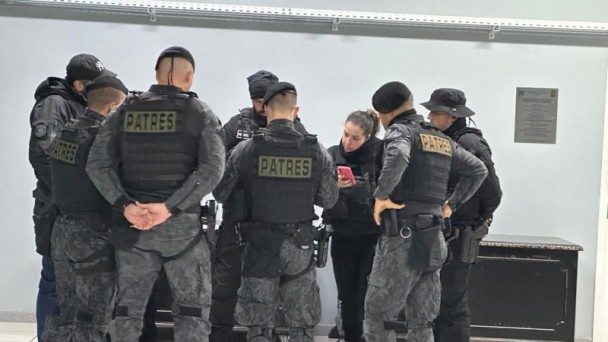 Oito agentes da Polícia Civil se preparam para a operação Via Clausum, sendo sete homens e uma mulher, que segura um celular