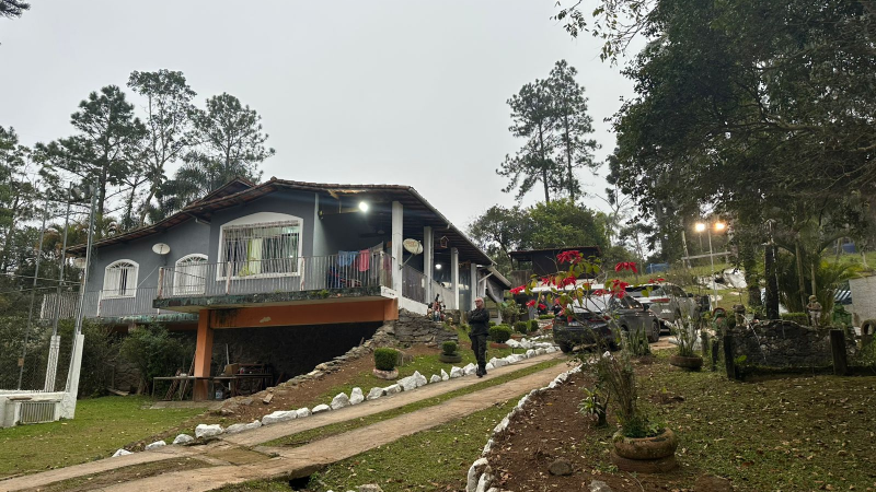 panorama de uma casa de dois pisos em propriedade rural com jardim e carros estacionados