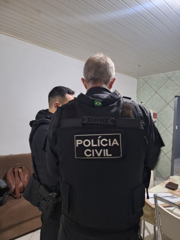 Dois policiais civis procuram evidências em residência