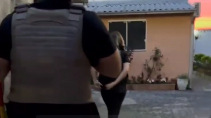 Policiais Civis entram em casa de cor alaranjada no alvorecer