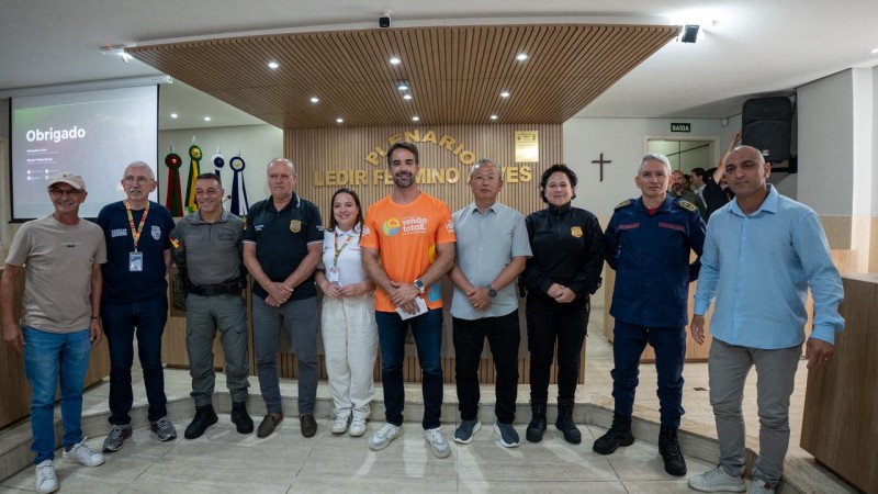 Dez pessoas est&atilde;o lado a lado de p&eacute; em pose para foto em um grande sal&atilde;o da C&acirc;mara de Vereadores de Xangri-l&aacute;