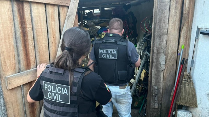 Dois policiais da &ldquo;POL&Iacute;CIA CIVIL&rdquo; entram em um galp&atilde;o ou dep&oacute;sito de madeira. Eles usam coletes t&aacute;ticos e parecem realizar uma busca. O espa&ccedil;o est&aacute; cheio de objetos, como bicicletas, ferramentas e materiais de limpeza. A porta de madeira est&aacute; parcialmente aberta, refor&ccedil;ando a ideia de inspe&ccedil;&atilde;o ou investiga&ccedil;&atilde;o.