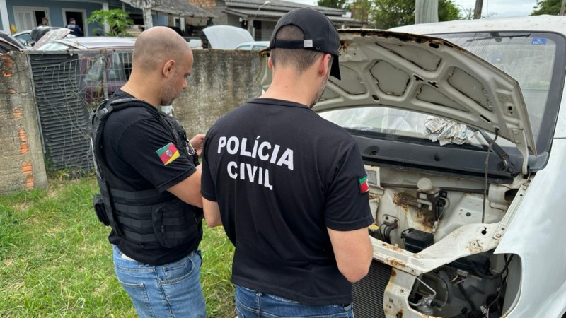 A imagem mostra dois servidores da Pol&iacute;cia Civil verificando um ve&iacute;culo durante a Opera&ccedil;&atilde;o Desmanche
