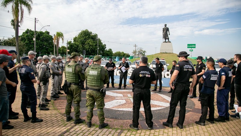 A imagem mostra servidores das for&ccedil;as de seguran&ccedil;a do Estado reunidos pr&oacute;ximo a est&aacute;tua da La&ccedil;ador, em Porto Alegre, durante o briefing da 100&ordf; Opera&ccedil;&atilde;o Fios e Cabos