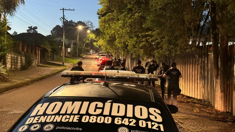 Carro do DHPP preto com os dizeres no vidro traseiro: Hom&iacute;cidios, Denuncie 0800 642 0121