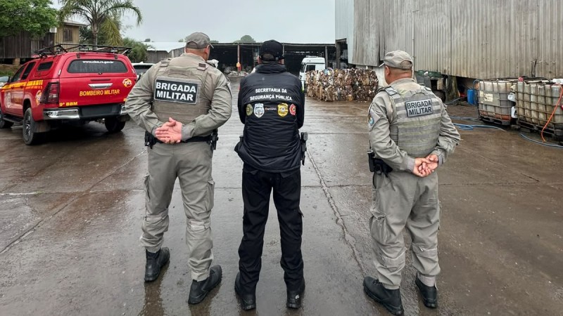 A imagem mostra tr&ecirc;s servidores das for&ccedil;as de seguran&ccedil;a em uma &aacute;rea externa, durante a opera&ccedil;&atilde;o Fios e Cabos